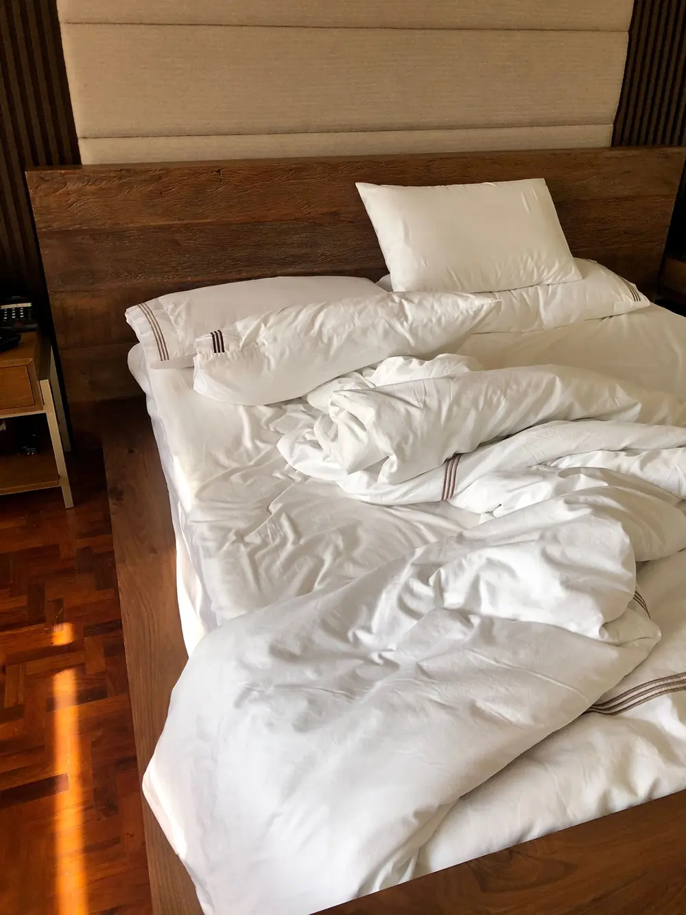 Un lit aux draps blancs froissés, vu de dessus