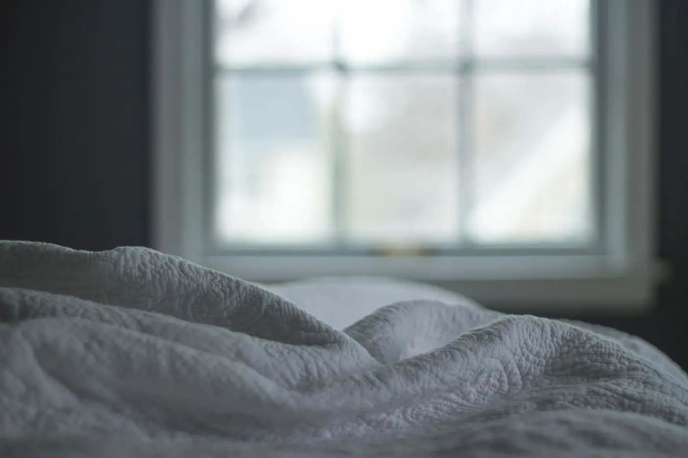 Un drap de lit froissé devant une fenêtre